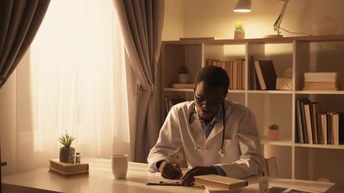 Doctor Writes Patient Notes in Warm Office