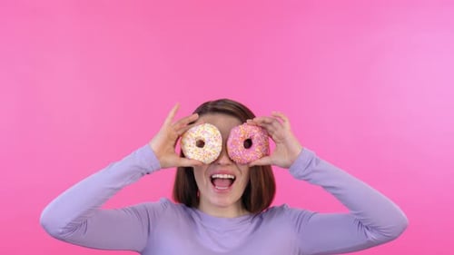 Cheerful Woman Holds Donuts Up to Eyes