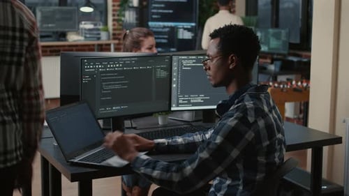 Young Adult Man Coding at Urban Workplace