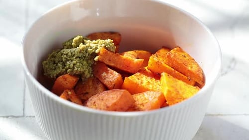 Sweet Potato Cubes Being Mixed with Pesto
