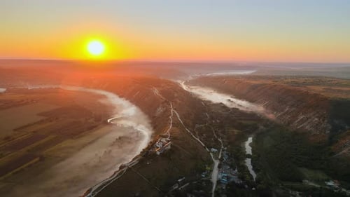 Aerial drone view of the Old Orhei at sunset. Valley with river and fog, village, monastery located