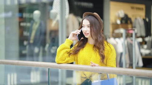 Stylish Woman Talking on Phone in Shopping Center
