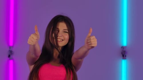 Smiling Woman Giving Thumbs Up With Bright Lighting