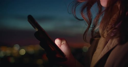 Woman Uses Phone at Night in City
