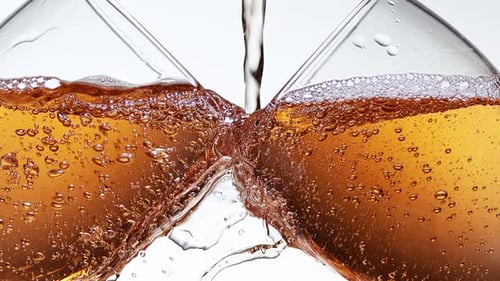 Pouring Sparkling Beverage into Two Wine Glasses