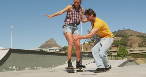 Woman Learns Skateboarding with Help in Urban Skatepark