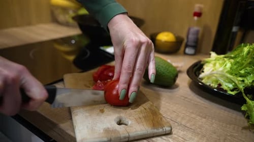 Person Cutting Fresh Tomato in Sunny Kitchen