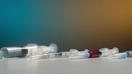 Syringes with Needles Lying on White Surface