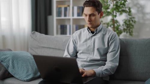 Young Adult Male Typing on Laptop at Home