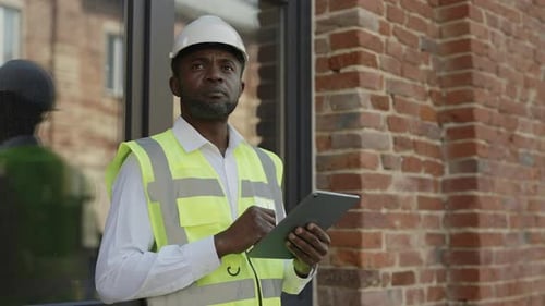 Pensive Architect Working on Tablet Near Construction Site
