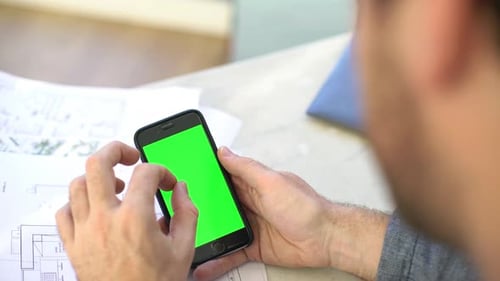 Man using multimedia smartphone, over the shoulder view