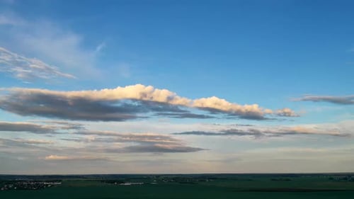Grüne Wiese unter einem blauen Sonnenuntergangshimmel mit Wolken