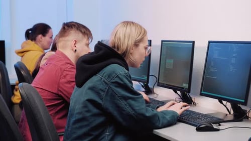 Young Adults Coding Together at Computers