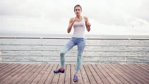 Young Woman Doing Cardio Exercise on Beach Boardwalk
