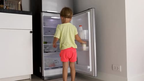 Young Boy Drinking Milk from the Fridge