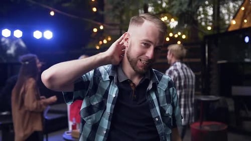 Man Dancing at an Outdoor Party at Night