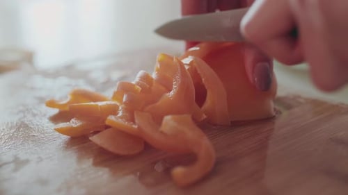 Female Hands Slicing Red Pepper for Salad on Kitchen, Close View