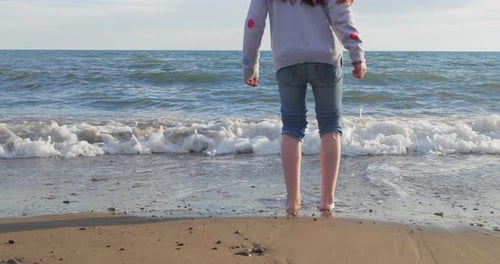 Little Girl Playing on the Beach in Summer