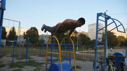 Strong Man Doing Push Ups on Sports Equipment at Playground