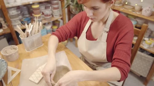 Caucasian Pottery Artist Working on Handmade Clay Bowl in Studio
