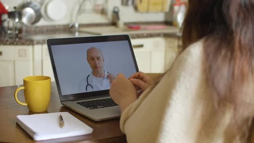 Woman having telehealth appointment on laptop at home