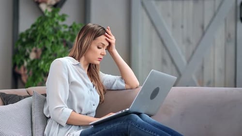 Woman Working on Laptop at Home, Gets Frustrated