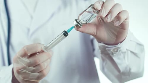 Medical Professional Drawing Vaccine Into Syringe