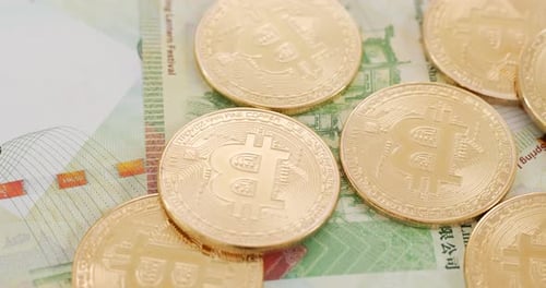 Bitcoin and Hong Kong banknote in spinning