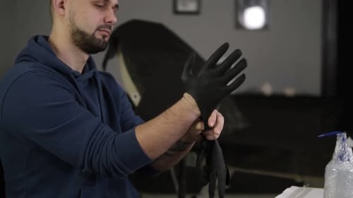 Close Up of Hands Tattoo Artist Putting on the Latex Black Gloves Before a Tattoo Session at the