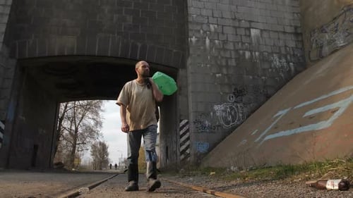 Full Length Unemployed Man Walking Under Bridge