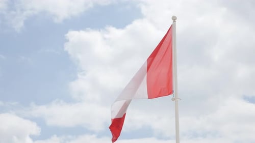 Canadian Flag Waving Against Cloudy Sky
