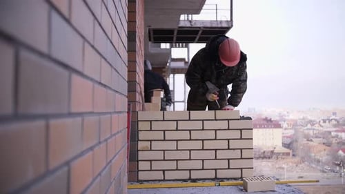 Workers Building a Brick Wall on Construction Site