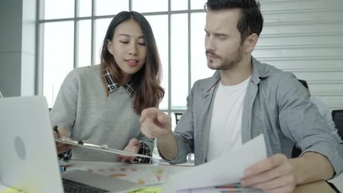 Business Professionals Collaborating on Project in Modern Office