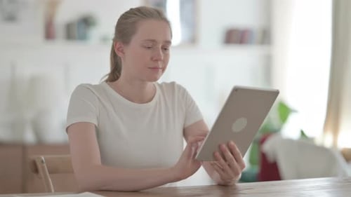 Beautiful Young Woman Using Tablet While Sitting in Office