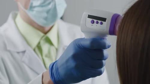 Doctor Taking Temperature of Patient with Thermometer