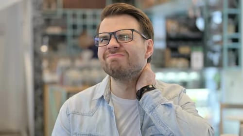 Man with Neck Pain Rubbing his Neck