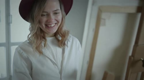 Smiling Woman Painting Indoors in Art Studio