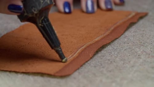Craftsperson Applying Glue to Leather Piece