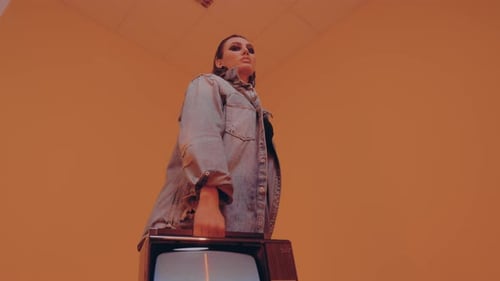 Woman with Old Television in Peach Colored Room