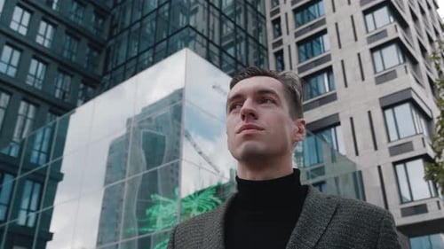 Man in business wear puts on sunglasses outdoors