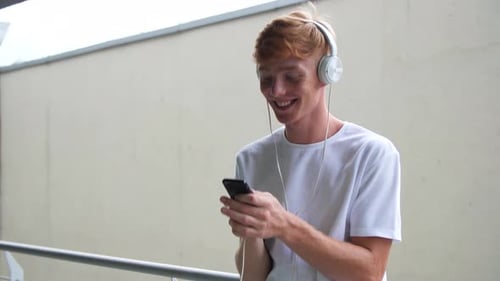Man Enjoys Music on Phone with Headphones