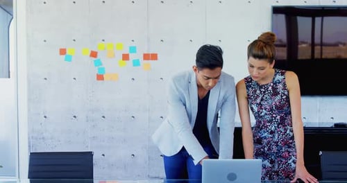 Colleagues Collaborating on Laptop in Modern Office