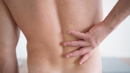Man Rubbing Sore Lower Back Muscles