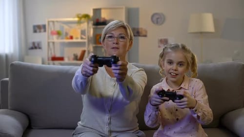 Grandmother and Granddaughter Enjoying Video Games at Home