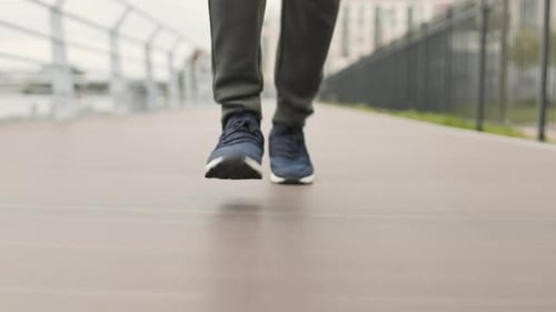 Unrecognizable Runner Running along Bridge