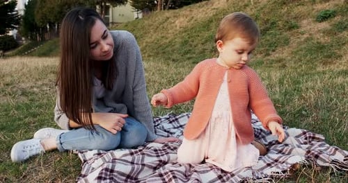 Mother and a Small Daughter, Spends Time Together in a City Park on a Picnic. Young Woman and Little