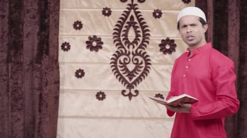 Man in Kufi Reading Book Indoors