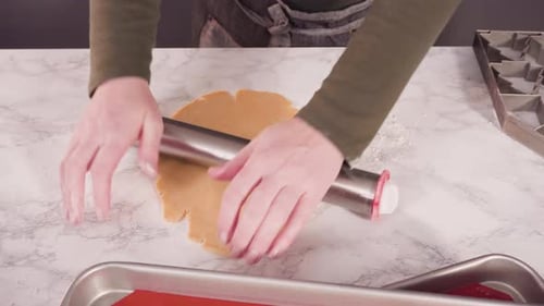 Hands Flatten Cookie Dough with Rolling Pin