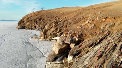 Rocky Cliff of Frozen River or Lake Amazing Landscape in Sunny Winter Day Aerial View