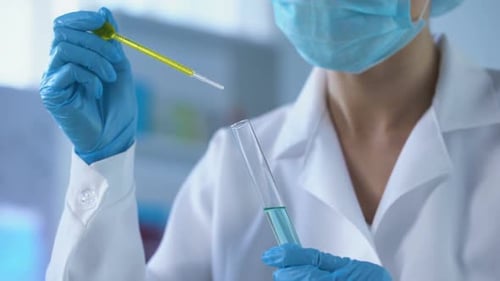 Person With Pipette Mixing Liquids in Test Tube